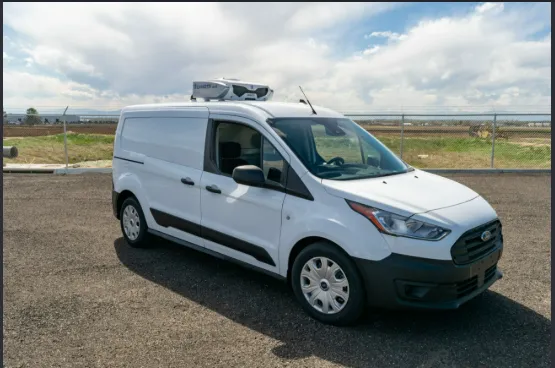 White compact refrigerated van with a roof-mounted reefer unit parked outdoors