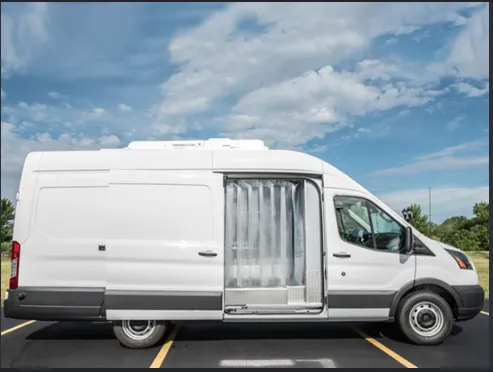 Side view of a white refrigerated van with the side door open and a strip curtain